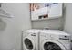 Laundry room with white washer and dryer, upper cabinets, and shelving at 1506 Ivy Bluff Way, Matthews, NC 28105