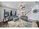 Bright living room with hardwood floors, blue sofas, and stairs leading to the second floor at 1506 Ivy Bluff Way, Matthews, NC 28105