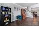 Cozy living room with dark hardwood floors, a bookshelf, and a comfortable blue chair offers a relaxing space at 1506 Ivy Bluff Way, Matthews, NC 28105