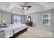 Bright main bedroom featuring neutral walls, a large window, and a wooden dresser with mirror at 1506 Ivy Bluff Way, Matthews, NC 28105