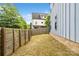 Backyard featuring lush trees, a wooden fence, and exterior siding of the home at 1513 Landis Ave, Charlotte, NC 28205