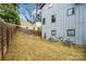 Backyard with exterior siding, lush trees, air conditioning units, and a wooden fence at 1513 Landis Ave, Charlotte, NC 28205