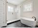 Modern bathroom with a glass-enclosed shower, a freestanding tub, and dark tile accents for a sleek design at 1513 Landis Ave, Charlotte, NC 28205