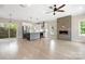 Spacious living room open to kitchen featuring a modern fireplace, recessed lighting, and beautiful wood floors at 1513 Landis Ave, Charlotte, NC 28205