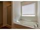 Modern bathroom featuring soaking tub, separate glass shower, and a bright window at 159 Saye Pl, Mooresville, NC 28115