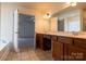 Bathroom featuring double sinks, wooden cabinets, and a large mirror at 159 Saye Pl, Mooresville, NC 28115
