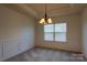 Cozy dining room featuring wainscoting, a window, and a chandelier that offer a classic touch at 159 Saye Pl, Mooresville, NC 28115
