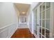 Bright hallway with hardwood floors, wainscoting, and glass french doors, offering a seamless transition at 159 Saye Pl, Mooresville, NC 28115