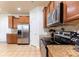 Well-lit kitchen featuring stainless steel appliances, wooden cabinets, granite countertops, and tile flooring at 159 Saye Pl, Mooresville, NC 28115