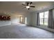 Bright living room boasts large windows, neutral paint, plush carpet, and a ceiling fan at 159 Saye Pl, Mooresville, NC 28115