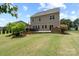 Scenic backyard view showcasing a well-maintained lawn, patio with pergola, and colorful flower beds at 16114 Foreleigh Rd, Huntersville, NC 28078