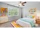 Bright bedroom with a cozy bed, stylish decor, ceiling fan, and natural light from a large window at 16114 Foreleigh Rd, Huntersville, NC 28078