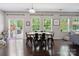 Open dining area with large windows overlooking a lush backyard and a modern table set for six at 16114 Foreleigh Rd, Huntersville, NC 28078