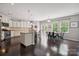 Bright and open kitchen featuring white cabinets, granite countertops, stainless steel appliances, and a dining area at 16114 Foreleigh Rd, Huntersville, NC 28078