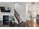 Inviting living room features a fireplace, dark wood floors, and an open staircase to the upper level at 16114 Foreleigh Rd, Huntersville, NC 28078