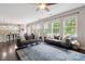 Bright living room featuring hardwood floors, large windows, and comfortable seating arrangement at 16114 Foreleigh Rd, Huntersville, NC 28078