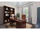 Elegant home office featuring a large wooden desk, built-in bookshelf, and natural light from a window at 16114 Foreleigh Rd, Huntersville, NC 28078