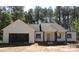 New construction home featuring a welcoming front porch, attached garage, and stylish exterior with trees in the background at 1761 Every Dr, Iron Station, NC 28080