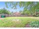 Large backyard, with a wooden privacy fence, lush green grass and mature trees at 2001 Tyvola Rd, Charlotte, NC 28210