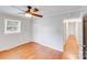 This bedroom features hardwood floors, closet space, a ceiling fan, and a large window for natural light at 2001 Tyvola Rd, Charlotte, NC 28210