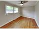 This bedroom has hardwood floors, two windows, ceiling fan and painted in a neutral color at 2001 Tyvola Rd, Charlotte, NC 28210
