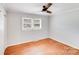 This bedroom features hardwood floors, neutral paint, a ceiling fan, and a large window for natural light at 2001 Tyvola Rd, Charlotte, NC 28210