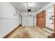 Attached garage with painted walls, concrete floor and garage door leading to backyard at 2001 Tyvola Rd, Charlotte, NC 28210