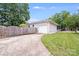 Attached garage with white garage door and driveway, and fenced in backyard and greenery at 2001 Tyvola Rd, Charlotte, NC 28210