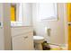 Bathroom featuring a white vanity, toilet, and neutral walls, complemented by bright yellow accents at 2012 Double Oaks Rd, Charlotte, NC 28206