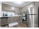 Functional kitchen featuring stainless steel appliances, neutral cabinets, and modern backsplash at 2012 Double Oaks Rd, Charlotte, NC 28206