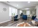 Open-concept living room featuring wood flooring, a comfortable sitting area, and a functional desk space at 2012 Double Oaks Rd, Charlotte, NC 28206