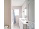 Clean bathroom with white cabinets, a shower with a blue-patterned curtain, and a neutral color scheme promoting a serene atmosphere at 2123 W Sixth Ave, Gastonia, NC 28052