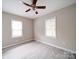 Sunlit bedroom with two windows, neutral walls, modern ceiling fan, and sleek wood-look floors create a bright space at 2123 W Sixth Ave, Gastonia, NC 28052