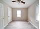 Bedroom with neutral walls, ceiling fan, and a window offering natural light over gray wood-look flooring at 2123 W Sixth Ave, Gastonia, NC 28052