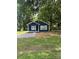 Quaint blue home surrounded by mature trees, featuring a well-maintained lawn at 2123 W Sixth Ave, Gastonia, NC 28052