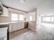 Modern kitchen with stainless steel appliances, white cabinets, and light wood-look flooring opens to the living room at 2123 W Sixth Ave, Gastonia, NC 28052