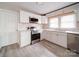 Modern kitchen featuring sleek stainless steel appliances, white cabinets, a window and light colored flooring at 2123 W Sixth Ave, Gastonia, NC 28052