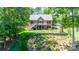 Backyard features a brick home with stairs leading to a patio, manicured lawn, and lush landscaping at 2580 Penngate Dr, Sherrills Ford, NC 28673