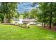 Lawn leading to a lake with waterfront docks and boat lifts, with mature trees framing the landscape at 2580 Penngate Dr, Sherrills Ford, NC 28673