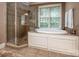 Bright bathroom features a soaking tub, shower, and tiled flooring at 2580 Penngate Dr, Sherrills Ford, NC 28673