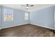 Bright bedroom featuring wood floors, large windows for natural light, and a ceiling fan at 2830 Berkhamstead Cir, Concord, NC 28027