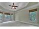 Spacious bedroom featuring a tray ceiling, neutral carpet, and a beautiful view from multiple windows at 298 Horton Grove Rd, Fort Mill, SC 29715