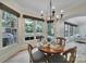 A dining room with a round wooden table, seating for four, a chandelier, and natural light from surrounding windows at 298 Horton Grove Rd, Fort Mill, SC 29715