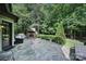 Stone outdoor patio with a built-in fireplace and comfortable seating surrounded by lush greenery at 298 Horton Grove Rd, Fort Mill, SC 29715