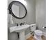 Chic powder room with pedestal sink, round mirror, and modern fixtures at 298 Horton Grove Rd, Fort Mill, SC 29715