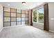 Bedroom with large windows and tree view, carpet, and unique wood paneling at 300 Hidden Cove Ln, Matthews, NC 28104