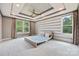Bedroom featuring tray ceiling, horizontal stripe wall, and modern platform bed at 300 Hidden Cove Ln, Matthews, NC 28104