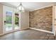 Bright dining area with stone accent wall, glass doors to backyard, and elegant lighting fixture at 300 Hidden Cove Ln, Matthews, NC 28104