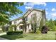 Side view of a two-story brick home with manicured landscaping and attached two-car garage at 300 Hidden Cove Ln, Matthews, NC 28104