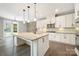 Modern kitchen with stone accent wall, island with sink, and backyard access through glass doors at 300 Hidden Cove Ln, Matthews, NC 28104